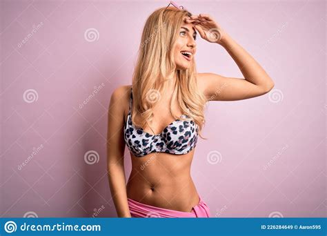 Joven Y Hermosa Mujer Rubia De Vacaciones Usando Bikini Sobre Un Aislado Fondo Rosado Muy Feliz