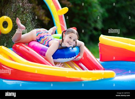 Children playing in inflatable baby pool. Kids swim and splash in ...