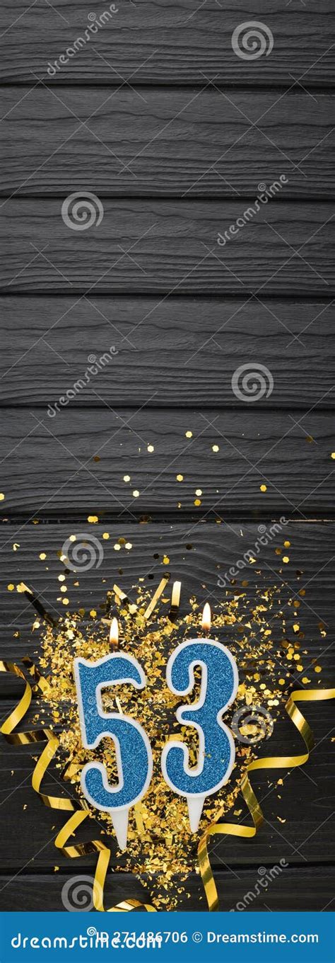 Number 53 Blue Celebration Candle And Gold Confetti On Dark Wooden