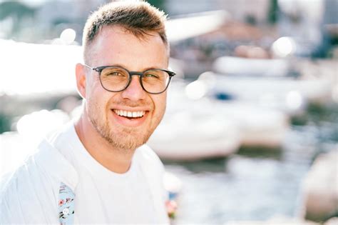 Premium Photo Laughing Young Man Sitting On The Pier Portrait