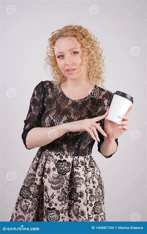 Cute Curly Blonde Girl Stands In Lace Short Evening Dress And Holds A