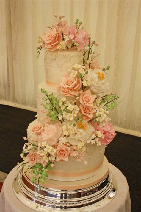 A Wedding Cake Decorated With Flowers And Greenery