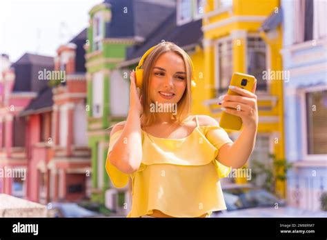 Portrait D Une Jeune Femme Blonde Dans Une Rue Avec Des Maisons Aux Fa Ades Color Es Derri Re