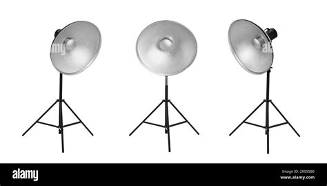 Set With Studio Flash Lights With Reflectors On Tripods Against White