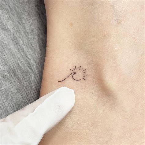 Minimalistic Style Sun And Wave Tattoo Located On The Minimalist