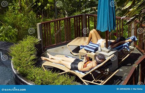 Mujeres Que Toman El Sol Al Lado De Piscina Foto De Archivo Imagen De