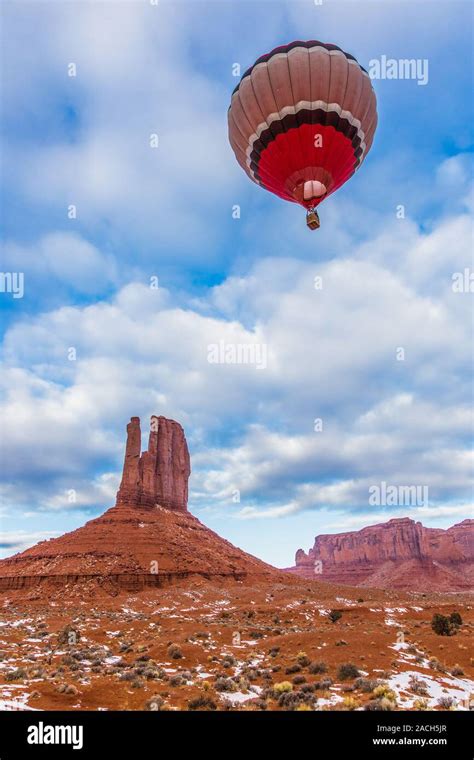 A Hot Air Balloon Flying In Front Of The West Mitten In The Monument