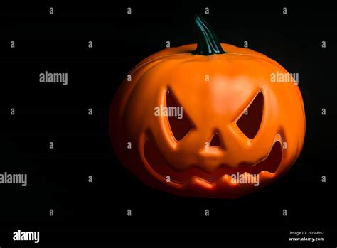 Ghostly Isolated Plastic Halloween Orange Pumpkin With Scary Face On