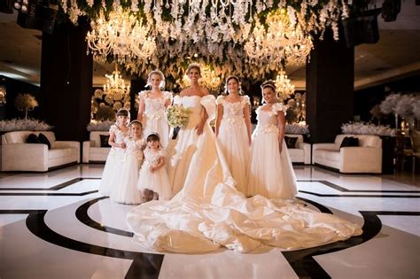 A Group Of Women Standing Next To Each Other In Front Of A Chandelier