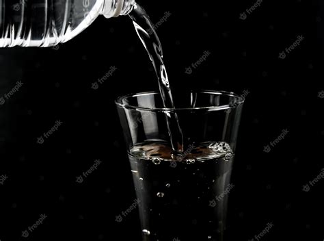 Premium Photo Pouring Fresh Water On Glass On Black Background