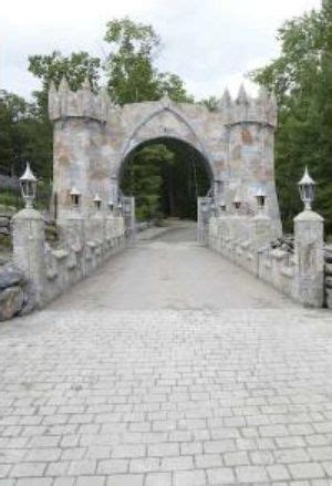 A Stone Bridge With An Arched Entrance Leading Into The Woods