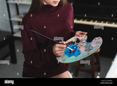 Partial View Of Girl In Burgundy Sweater Holding Paintbrush With