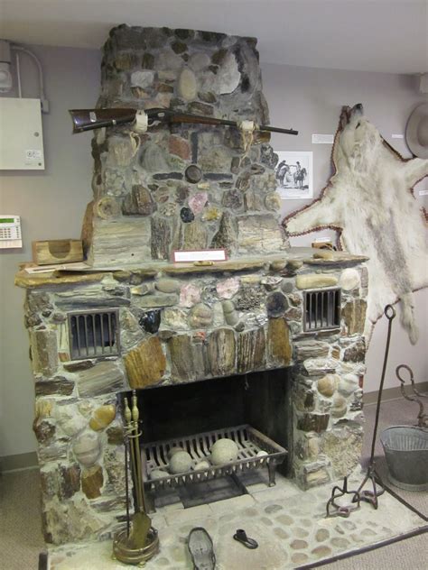 An Old Stone Fireplace In A Room With Other Items On The Table And Around It