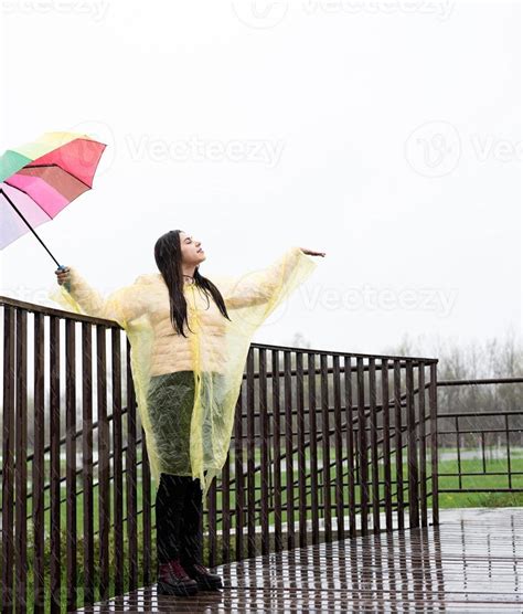 Beautiful Brunette Woman Holding Colorful Umbrella Out In The Rain