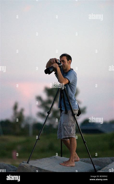 A Barefoot Photographer On A Rock At Sunset Stock Photo Alamy