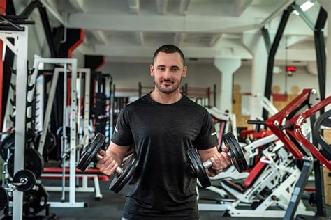 Hombre caucásico haciendo ejercicio con pesas en el gimnasio Foto Premium