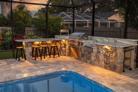 Custom Stone Outdoor Kitchen With Outdoor Lighting And Pizza Oven In