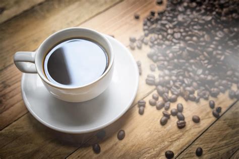 Coffee cup and beans on brown background 11550945 Stock Photo at Vecteezy