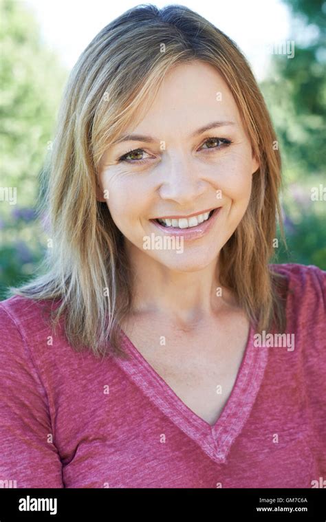 Outdoor Head And Shoulders Portrait Of Smiling Mature Woman Stock Photo