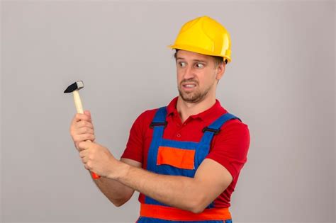 Homem jovem construtor em uniforme de construção e capacete de