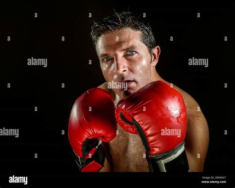 young angry and fierce sport man in boxing gloves posing in badass ...