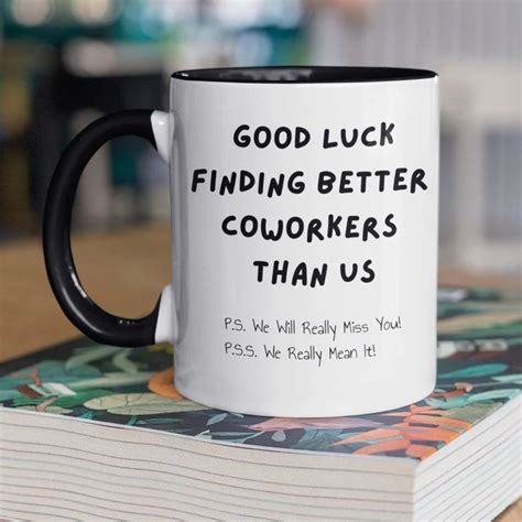 A Black And White Coffee Mug Sitting On Top Of A Stack Of Books That