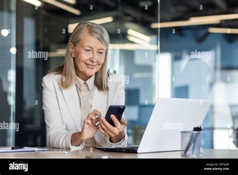 Senior Mature Experienced Woman At Workplace Inside Office Business Woman Happy Smiling Using