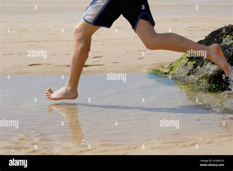 man running  water  beach england uk stock photo alamy