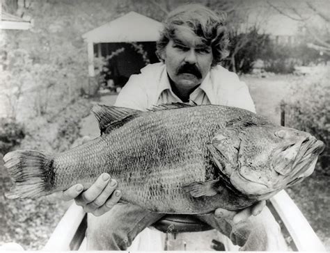 Black and white photo with man posing with the largest largemouth bass ...