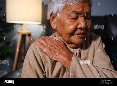 Senior Woman Suffering From Neck And Shoulder Pain While Sitting On A