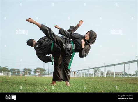 Asian Male And Female Fighters Wearing Pencak Silat Uniforms Face Each