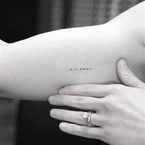 Minimalist Date Tattoo In Roman Numerals On The Right Inner Arm