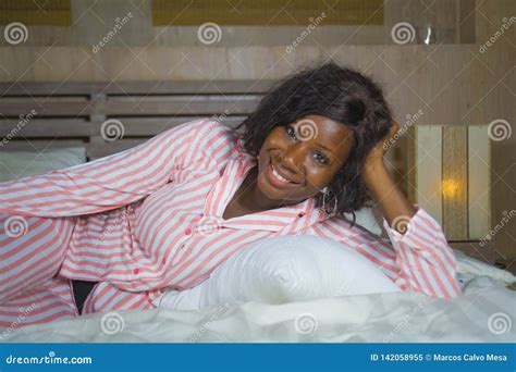 Young Happy And Beautiful Black African American Woman In Pajamas Lying