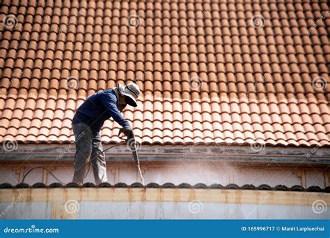 Roof Top Worker With Professional Equipment Cleaning The Roof Of The