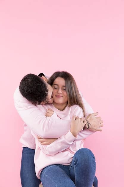 Homme Embrassant Une Jolie Femme Joyeuse Sur Un Tabouret Photo Gratuite