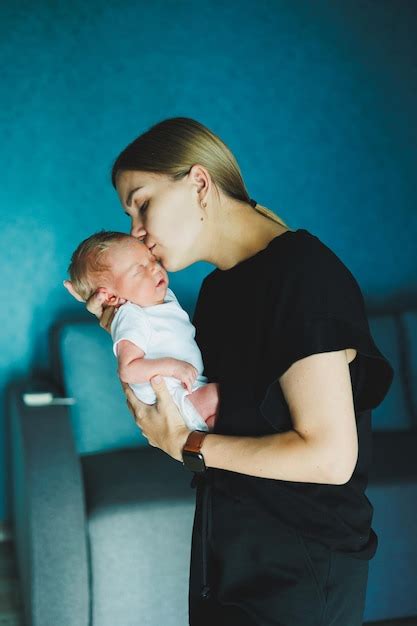 Una madre feliz sostiene a un recién nacido en sus brazos una joven