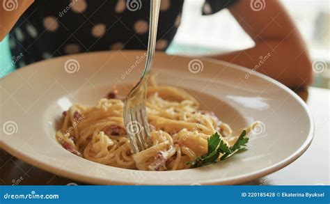 Beautiful Blonde With Glasses Eats Spaghetti Carbonara In A Restaurant