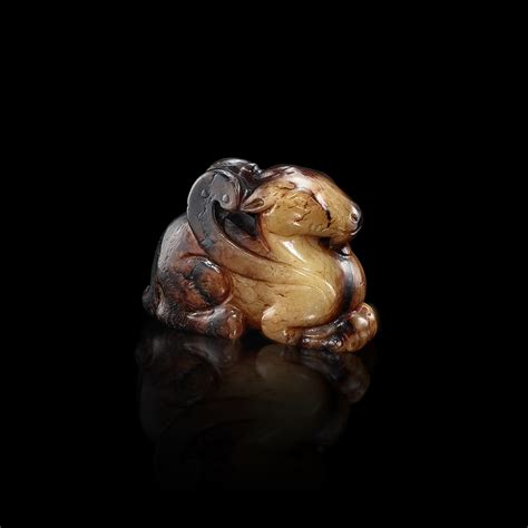 A white and brown jade mythical animal Ming dynasty or earlier 明或更早