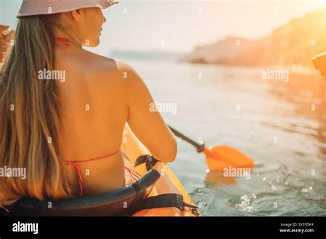 Woman Bikini Paddles Kayak On A Lake The Sun Is Shining Brightly Creating A Warm And Inviting