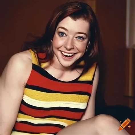 Alyson Hannigan Sitting On A Bed In A Hotel Wearing A Striped Sweater