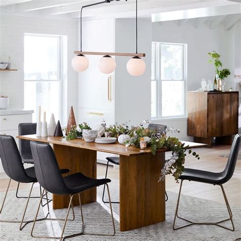 A Dining Room Table With Chairs And Plants On It