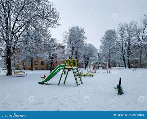 Kids Park with Slide and Swing Covered in Heavy Snow on a Cold Winter Morning during Holiday ...