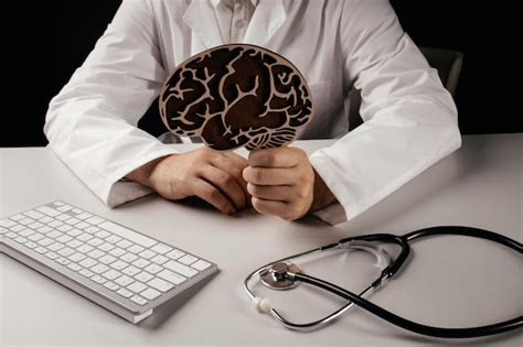 Doctor Sosteniendo Un Modelo De Cerebro De Madera Sentado En La Oficina