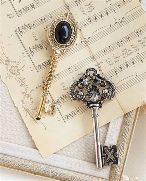 An Old Key Is Laying On Top Of Sheet Music And Has A Black Stone In The