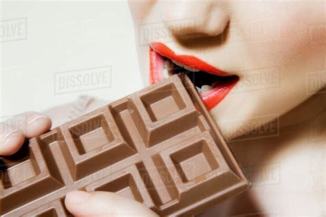 Young Woman Biting Chocolate Close Up Stock Photo Dissolve