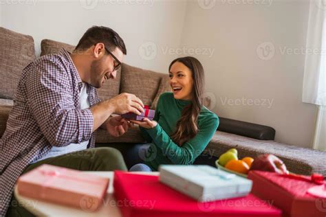 Couple exchanging gifts in their home 23909423 Stock Photo at Vecteezy