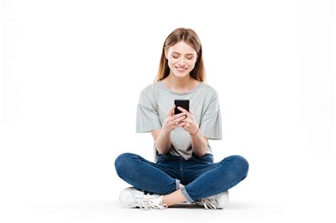 Woman Using Smartphone And Sitting On Floor Free Photo