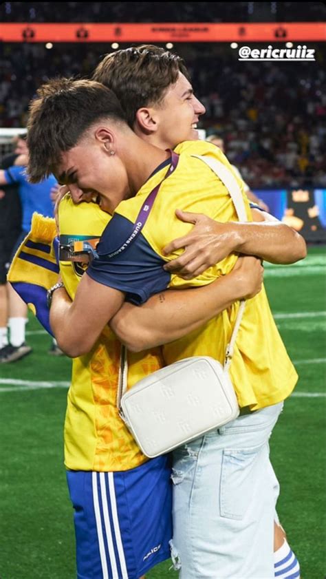 Two Soccer Players Hugging Each Other On The Field