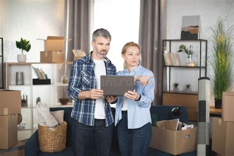 Mature Man And His Pretty Wife Using Laptop While Relocating To New Flat Stock Image Image Of