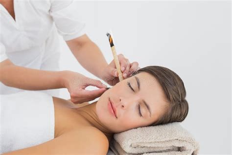 Beautiful Woman Receiving Ear Candle Treatment At Spa Center Stock